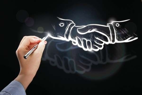 an artist drawing two hands shaking hands