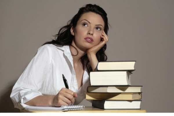 starting a blog - a writer next to a big pile of books